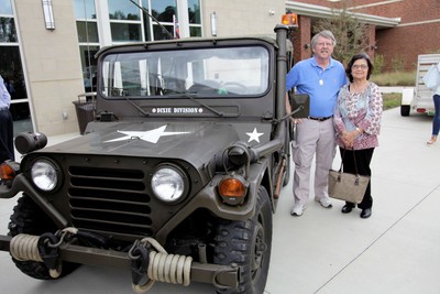 3.	On the grounds of Auburn High School Glenn McCarley and wife Thu pose beside a Jeep similar to the ones used in Vietnam. 